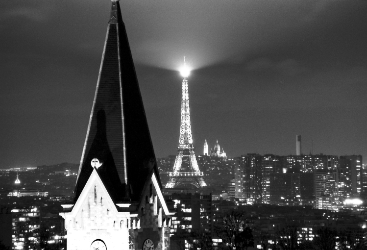 View from the apartment.  The camera was on a tripod, exposure set to 7 seconds, f-stop at 5.6 or 8, and the shutter was opened by a timer to avoid camera shake.  I got lucky and the shutter opened just as the Eiffel Tower's searchlight swept across the frame.